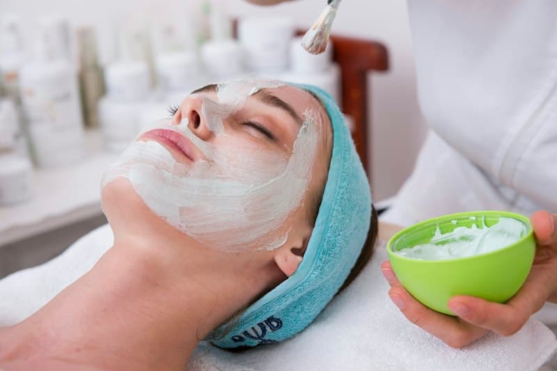 Khách đắp mặt nạ kem trắng, kỹ thuật viên cầm bát mặt nạ