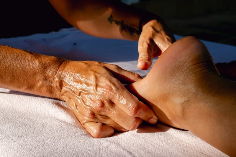 Massage bàn chân cho khách nằm trên giường