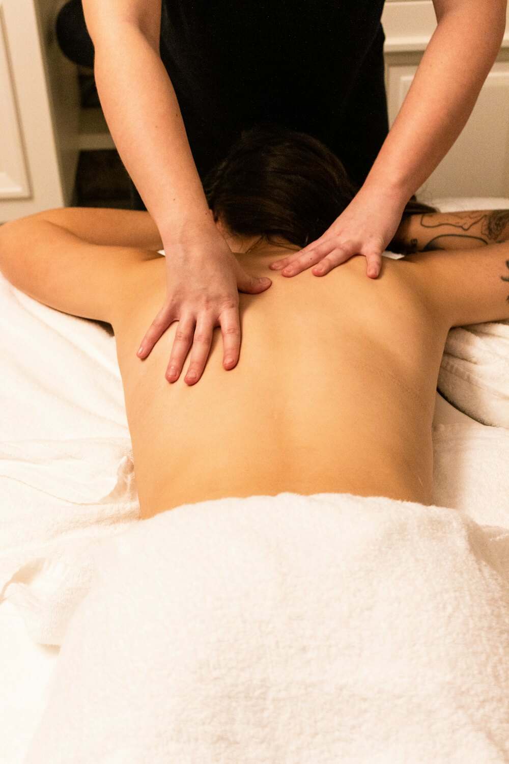 Kỹ thuật viên dùng hai tay massage lưng cho khách nằm sấp