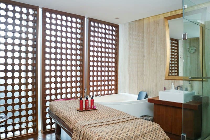 Phòng spa với vách gỗ chạm lỗ tròn và giường trị liệu