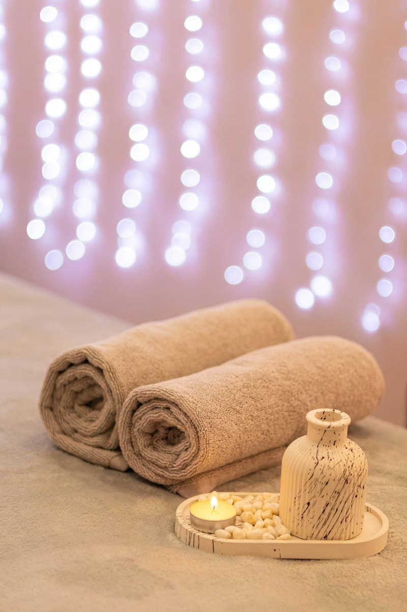 Khăn cuộn và nến nhỏ trên giường spa